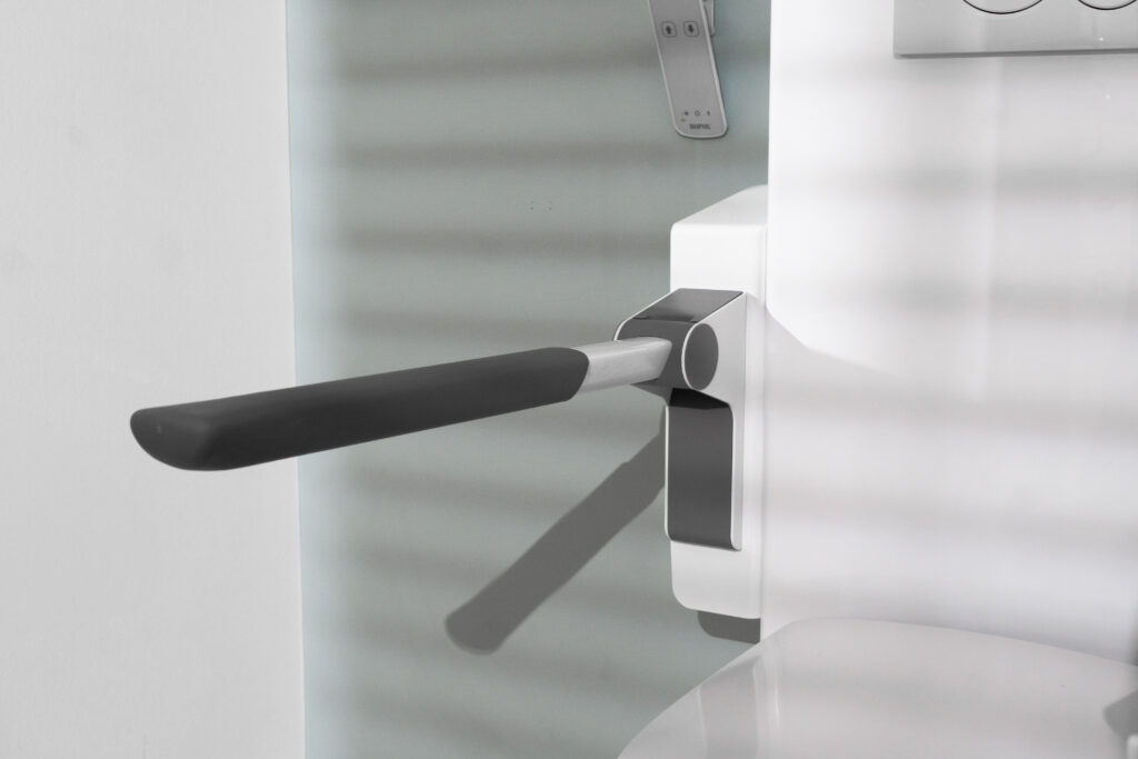 Close-up of toilet lifter support arm extended horizontally from wall bracket