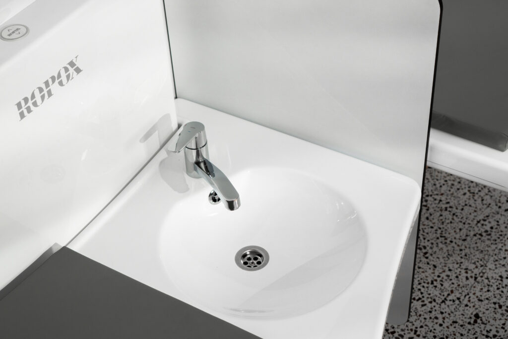 Close-up of integrated sink on Ropox nursing table with safety side panel