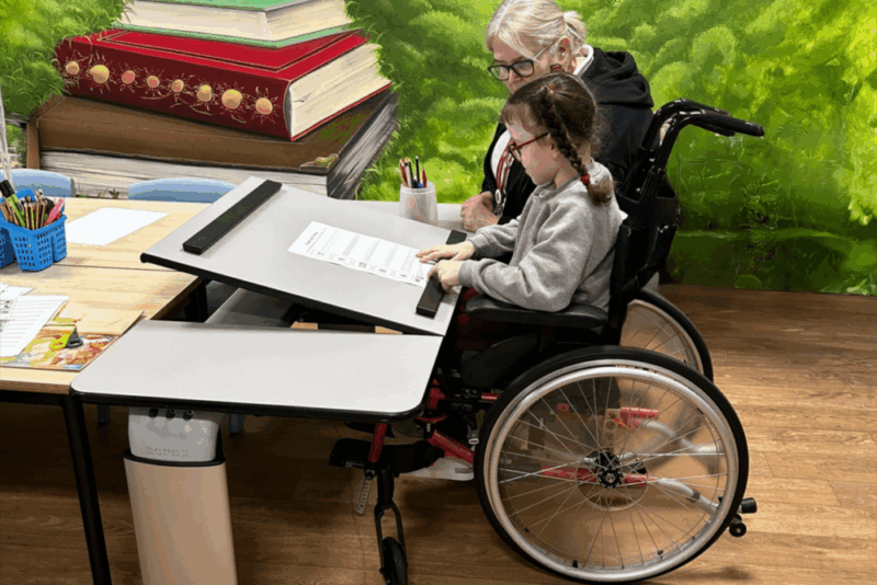 girl in a wheelchair using an adjustable Ropox Vision Table