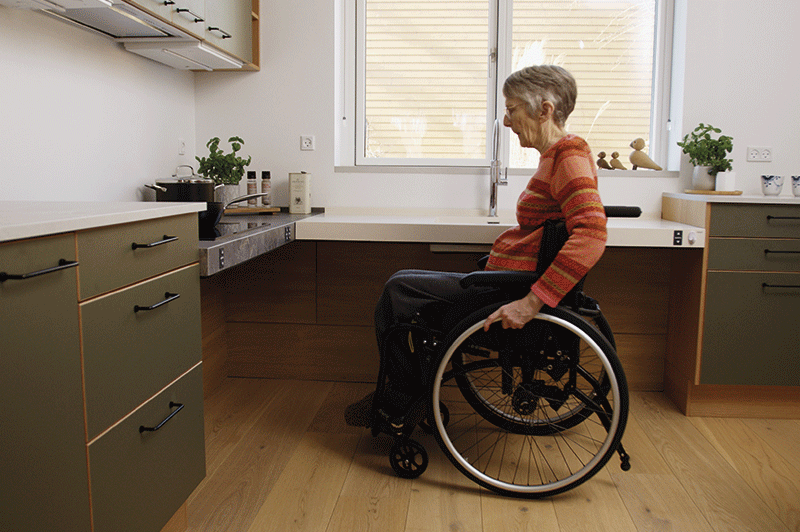 `Woman in wheelchair using accessible kitchen worktop`